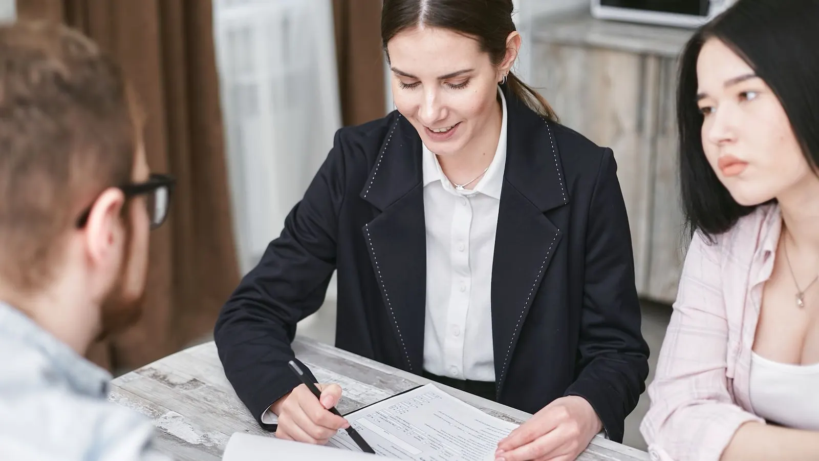 Business colleagues reviewing a document together across an office table.