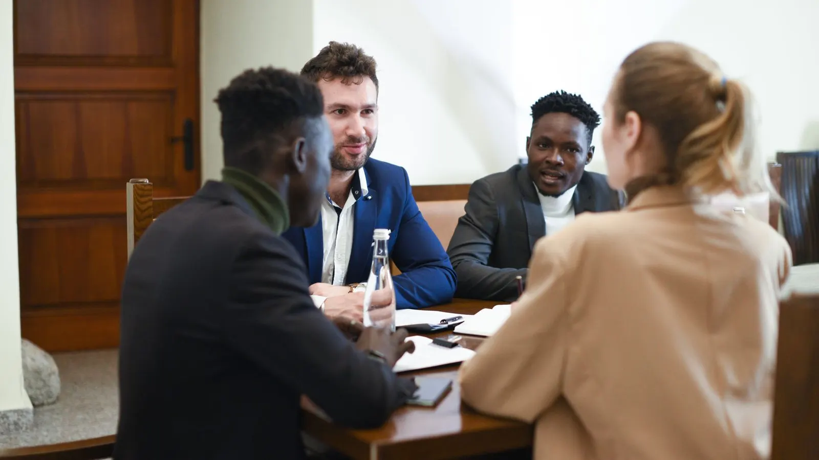 Business colleagues talking through paperwork together in a meeting room.
